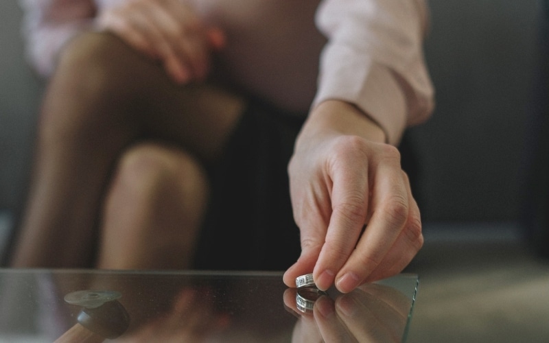 picture of an Alabama woman putting her wedding ring on a table after her divorce