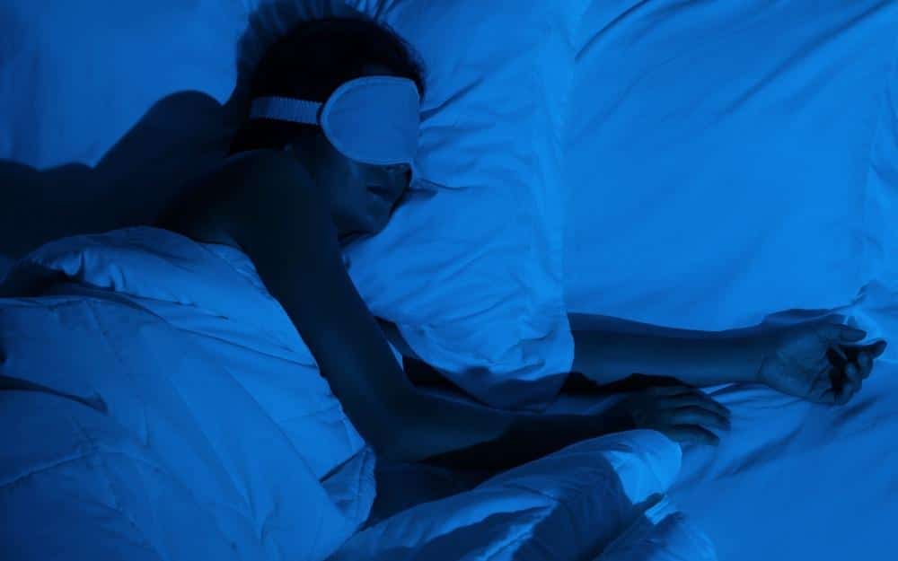 picture of a woman sleeping in bed and getting late night text message