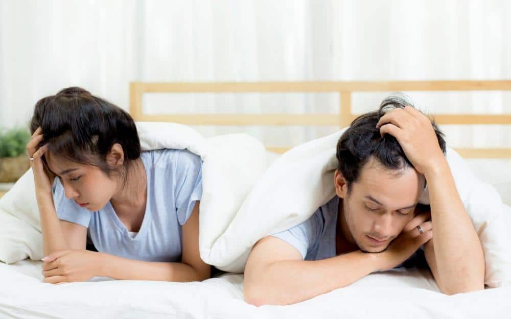 picture of married couple unhappy in bed together and not having sex