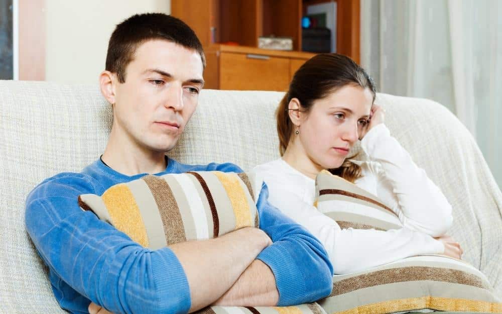 picture of a husband and wife on a couch after learning she cheated