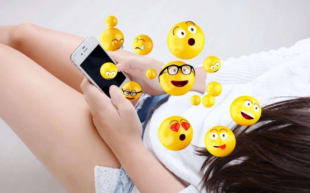 picture of a woman reading text messages with emoji's and being seduced